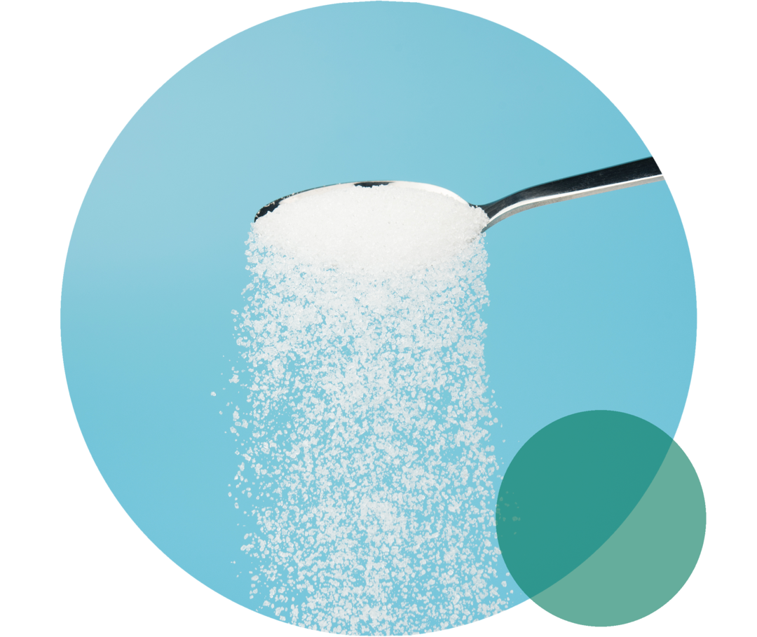 Von einem Teelöffel rieselt eine weiße Substanz herab.